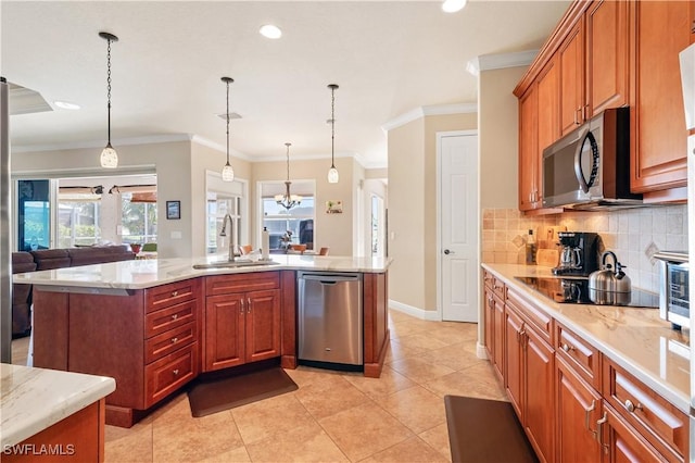 kitchen with appliances with stainless steel finishes, pendant lighting, a sink, and a center island with sink