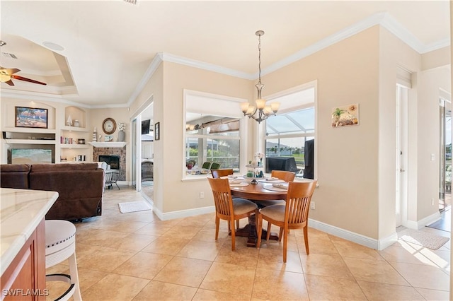 dining room featuring a fireplace, ceiling fan with notable chandelier, crown molding, and light tile patterned flooring