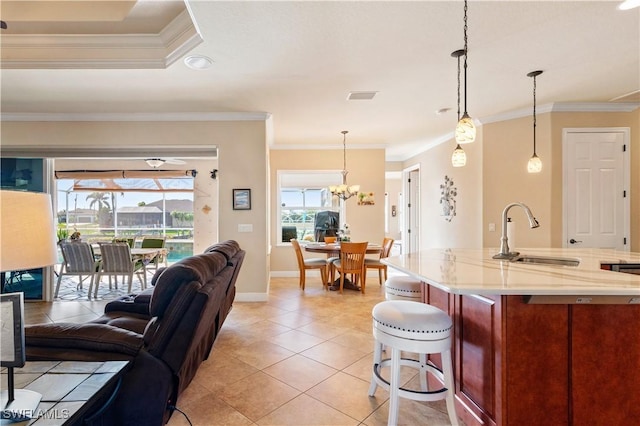 kitchen with visible vents, open floor plan, a sink, and decorative light fixtures