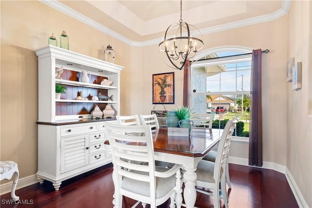 dining room featuring a notable chandelier, dark wood-style flooring, baseboards, a tray ceiling, and crown molding