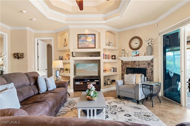 living room featuring arched walkways, built in shelves, light tile patterned flooring, a fireplace, and ornamental molding