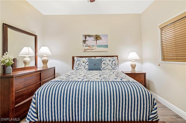 bedroom with baseboards and wood finished floors