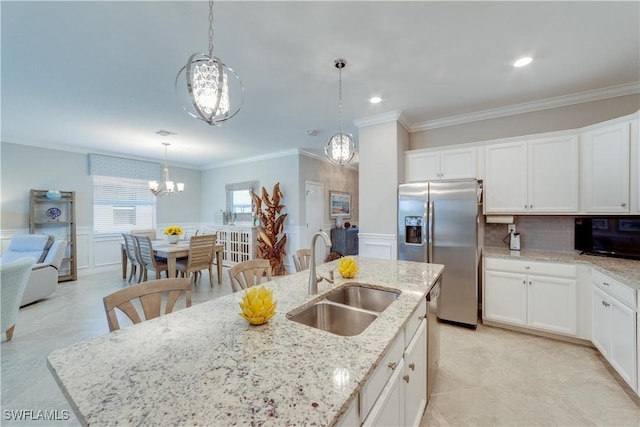 kitchen with appliances with stainless steel finishes, white cabinetry, a sink, and an island with sink