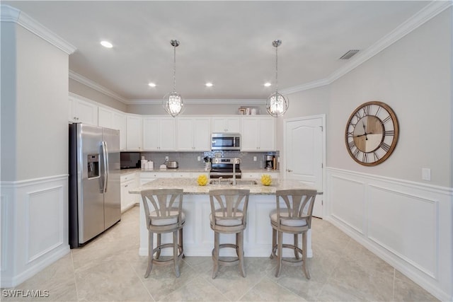 kitchen with visible vents, appliances with stainless steel finishes, white cabinetry, a sink, and light stone countertops