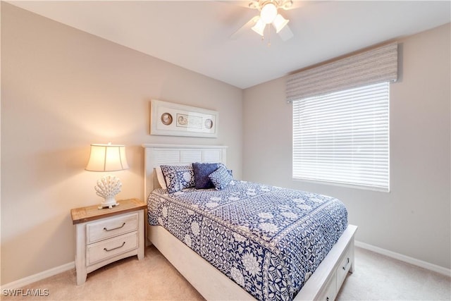 bedroom with light carpet, a ceiling fan, and baseboards