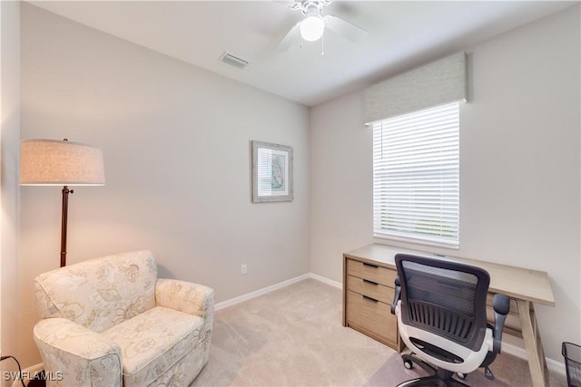 office space with baseboards, a ceiling fan, visible vents, and light colored carpet