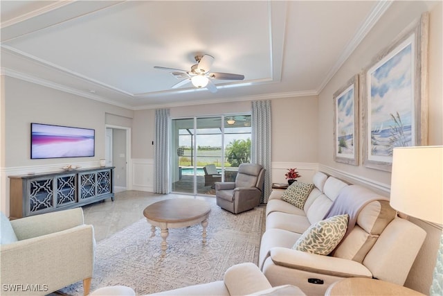 living room featuring a wainscoted wall, a decorative wall, ornamental molding, a sunroom, and ceiling fan