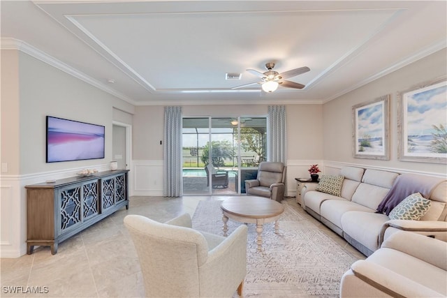 living area with a decorative wall, a wainscoted wall, a sunroom, visible vents, and crown molding