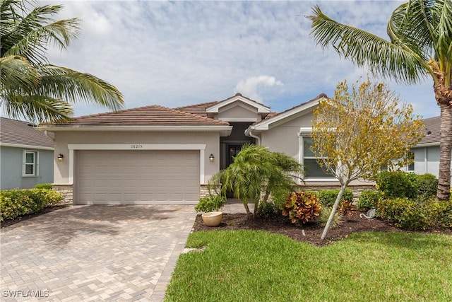 ranch-style house with an attached garage, stone siding, decorative driveway, and stucco siding