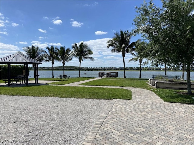 surrounding community featuring a gazebo, a lawn, and a water view