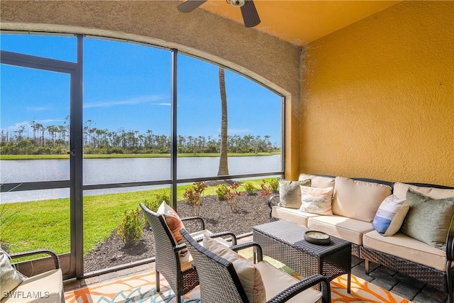 sunroom / solarium featuring a water view and ceiling fan