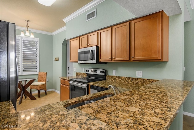 kitchen featuring arched walkways, visible vents, ornamental molding, appliances with stainless steel finishes, and dark stone counters