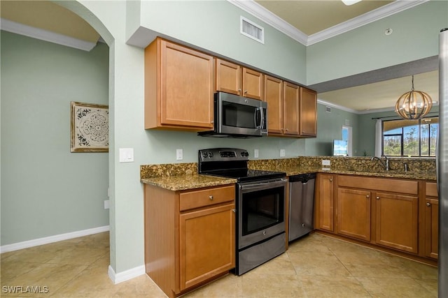 kitchen with a sink, visible vents, ornamental molding, appliances with stainless steel finishes, and dark stone counters