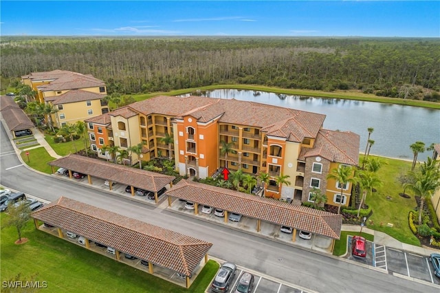 birds eye view of property with a water view and a wooded view