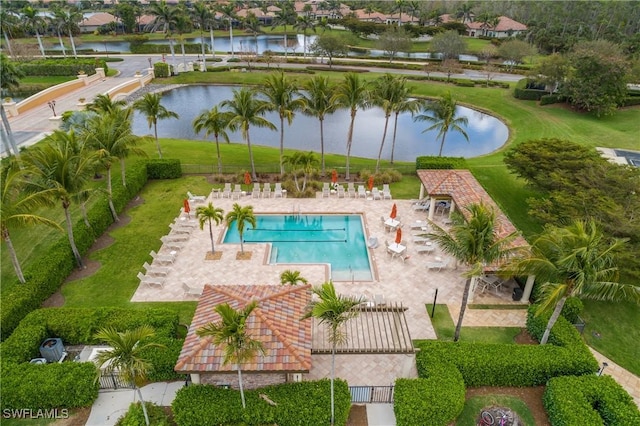 community pool with a water view, fence, and a patio