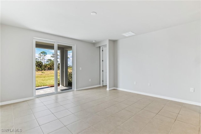 spare room with light tile patterned floors and baseboards