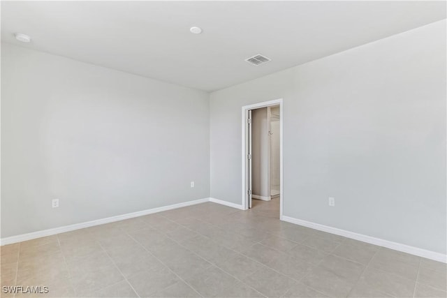 unfurnished room with baseboards and visible vents