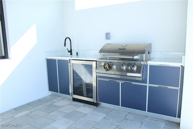 view of patio / terrace featuring a sink, a grill, beverage cooler, and exterior kitchen