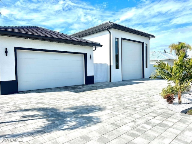 view of property exterior featuring decorative driveway and stucco siding