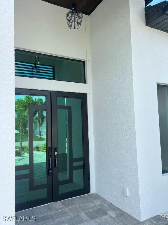 entrance to property with french doors and stucco siding