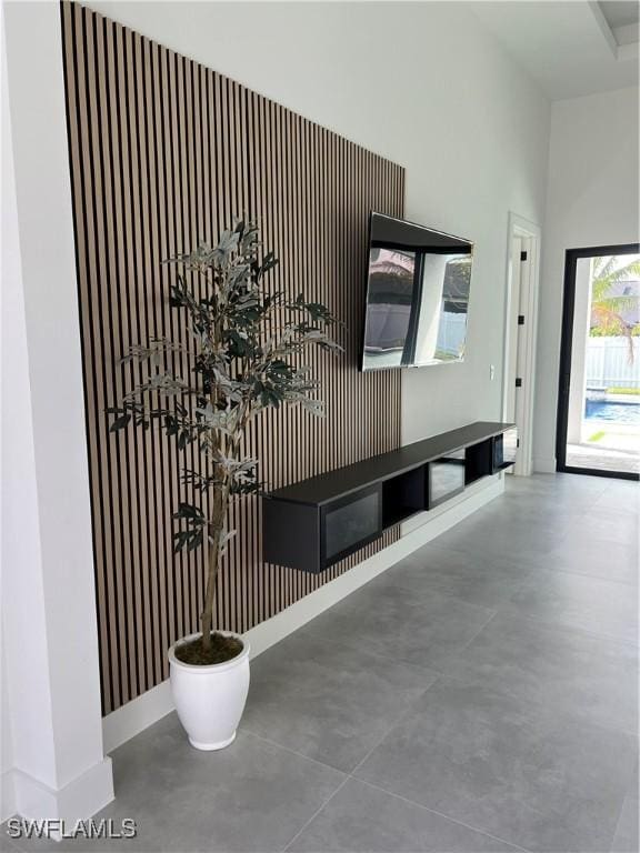 interior space with baseboards, finished concrete flooring, and a high ceiling