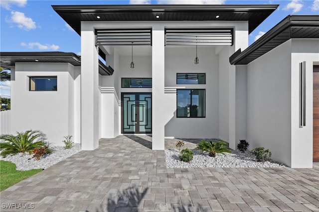 doorway to property featuring a garage and stucco siding