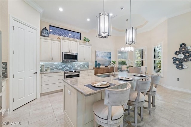 kitchen featuring crown molding, decorative backsplash, stainless steel appliances, and a sink