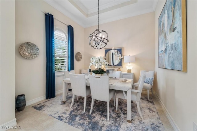 dining room featuring an inviting chandelier, baseboards, a tray ceiling, and ornamental molding