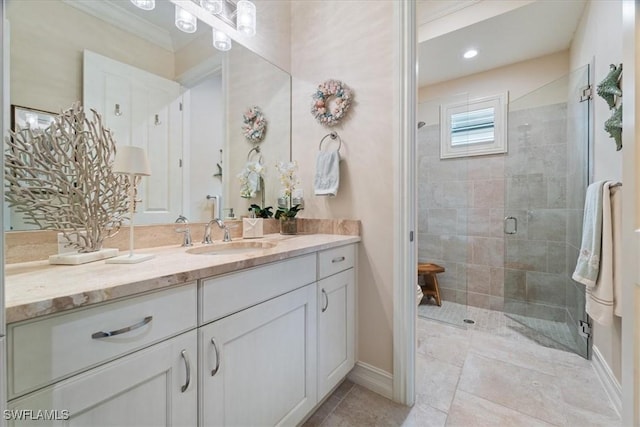 full bath featuring a stall shower, tile patterned flooring, vanity, and baseboards