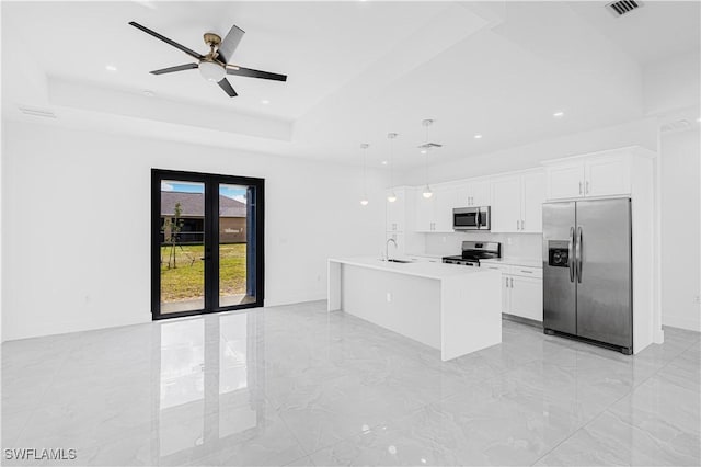 kitchen featuring light countertops, hanging light fixtures, appliances with stainless steel finishes, a sink, and an island with sink