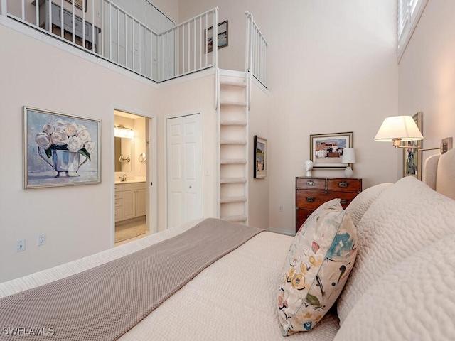 bedroom with a towering ceiling, a sink, and connected bathroom