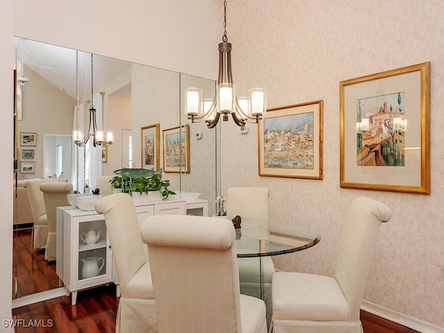 dining area featuring vaulted ceiling, wallpapered walls, a notable chandelier, and wood finished floors