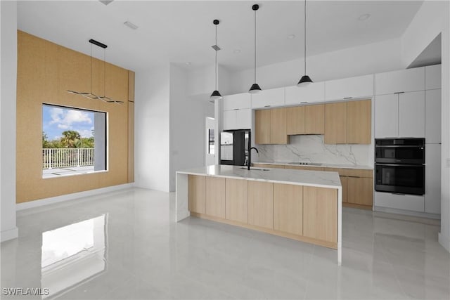 kitchen with hanging light fixtures, black appliances, modern cabinets, and white cabinetry