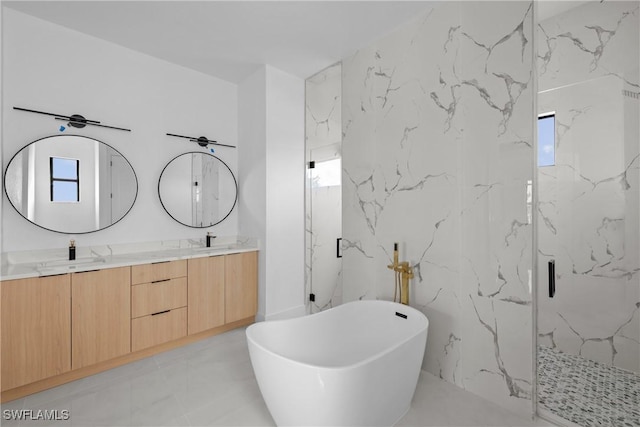 bathroom featuring marble finish floor, a marble finish shower, double vanity, a sink, and a freestanding tub