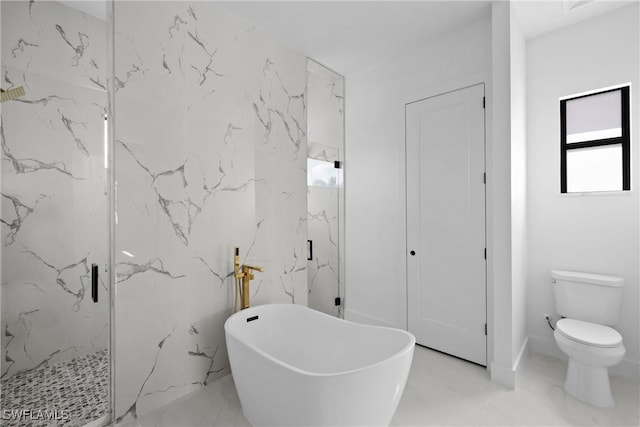 full bath featuring a marble finish shower, toilet, marble finish floor, a freestanding bath, and stone wall