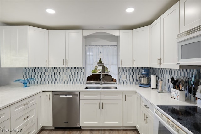 kitchen with white appliances, a sink, and white cabinetry