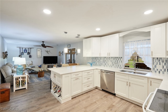 kitchen with open floor plan, light countertops, a sink, and stainless steel dishwasher