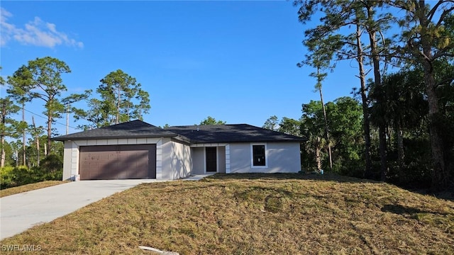 single story home featuring a garage, concrete driveway, and a front yard