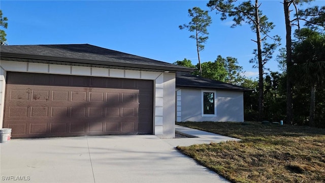 1125 Copley St E, Lehigh Acres, FL 33974 - view of side of property featuring a shingled roof and concrete driveway
