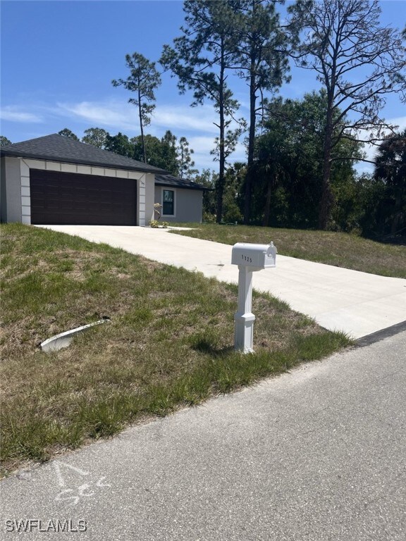 1125 Copley St E, Lehigh Acres, FL 33974 - view of front facade with driveway