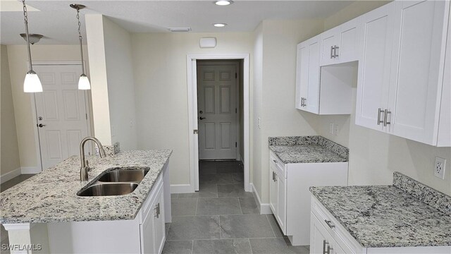 1125 Copley St E, Lehigh Acres, FL 33974 - kitchen with a sink, baseboards, light stone countertops, recessed lighting, and white cabinets