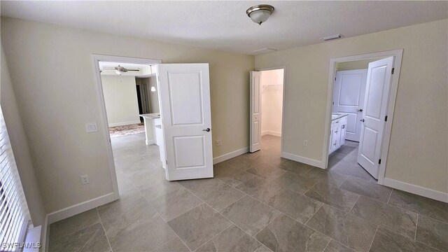 1125 Copley St E, Lehigh Acres, FL 33974 - unfurnished bedroom featuring a spacious closet, baseboards, a closet, and connected bathroom