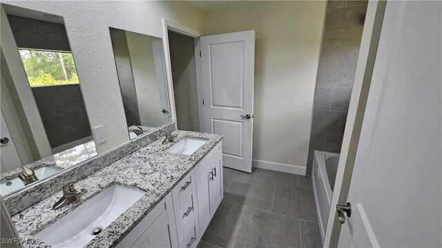1125 Copley St E, Lehigh Acres, FL 33974 - bathroom with baseboards, double vanity, tile patterned floors, and a bathtub