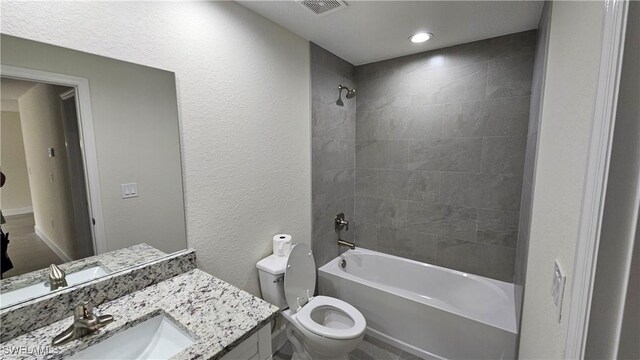 1125 Copley St E, Lehigh Acres, FL 33974 - full bathroom featuring toilet, tub / shower combination, vanity, and a textured wall