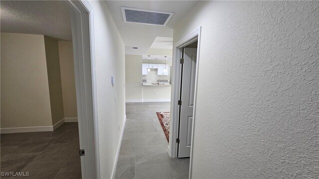 1125 Copley St E, Lehigh Acres, FL 33974 - hallway featuring a textured wall, baseboards, and tile patterned floors