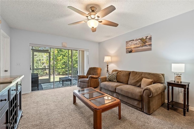 living room with light carpet, ceiling fan, a textured ceiling, and baseboards