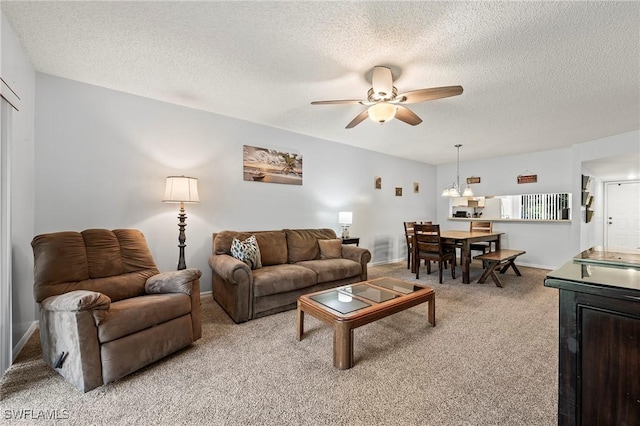 living area featuring light carpet, a textured ceiling, and a ceiling fan