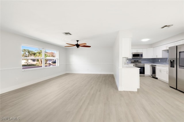 kitchen featuring stainless steel appliances, light countertops, visible vents, open floor plan, and white cabinets