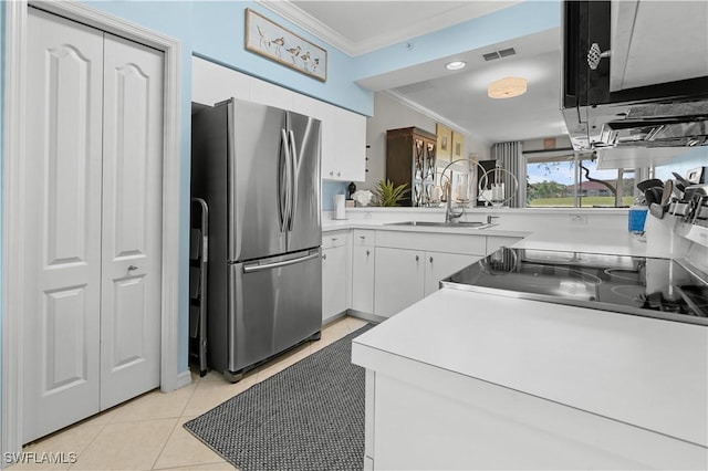 kitchen with visible vents, freestanding refrigerator, light countertops, crown molding, and white cabinetry