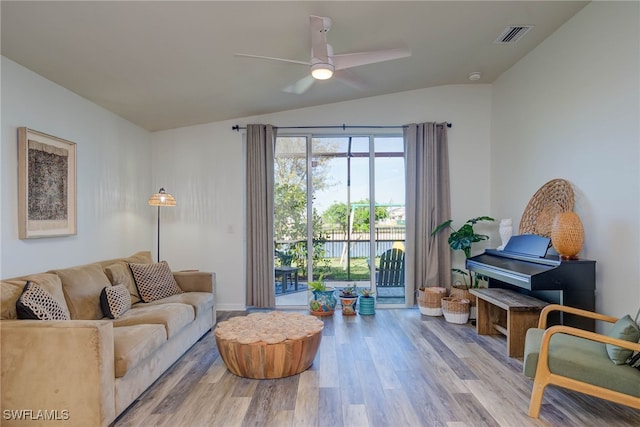 living area with lofted ceiling, visible vents, ceiling fan, and light wood-style flooring